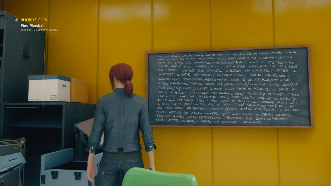 Jesse stands in front of a chalkboard with song lyrics written on it.