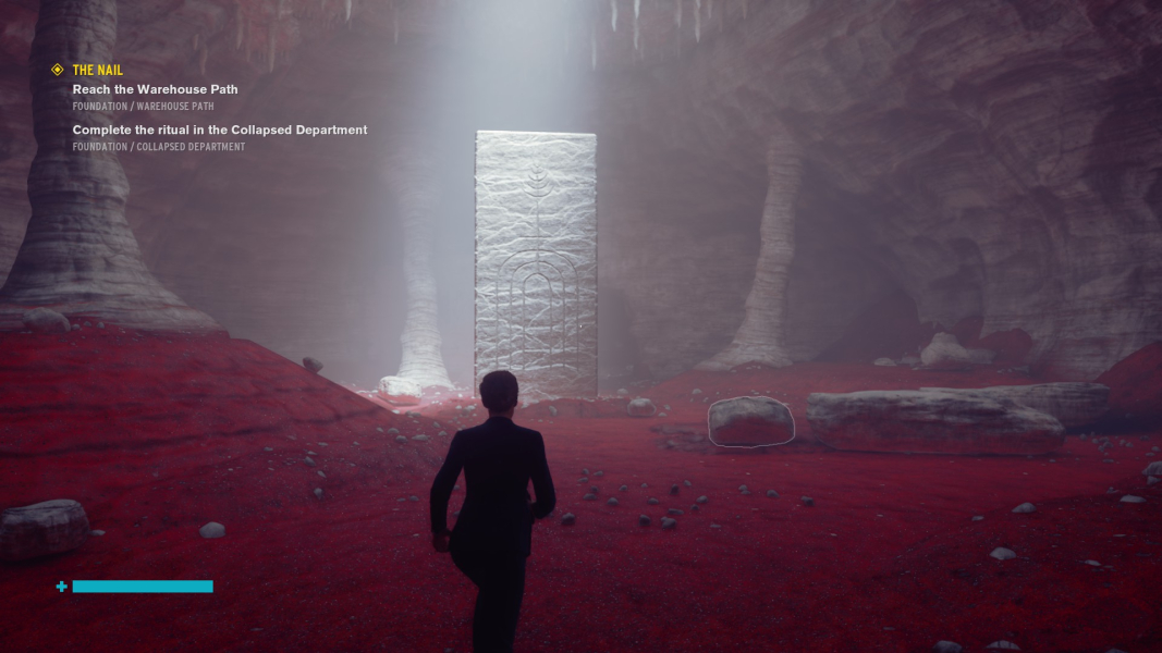 A carved pillar in the middle of a red sand room with a familiar carving.